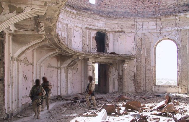 US Commandos patrolling a heavily bombed room in the palace in 2002