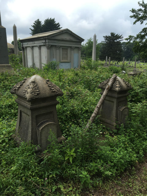 Overgrown and abandoned tombstones, sepulcher with obelisks in the back Author: Shannon McGee CC BY-SA 2.0
