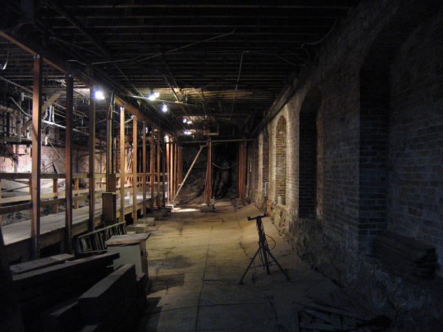 The concrete floor of the former meat market was originally at the level of the wooden platform on the left but sank over time because of decomposing sawdust fill. Author: Postdlf CC BY-SA 3.0