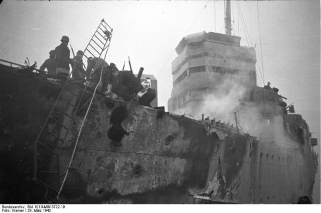 Close up of HMS Campbeltown after the raid. Note the shell damage in the hull and upper works and the German personnel on board the vessel – Author: Bundesarchiv, Bild 101II-MW-3722-19 / Kramer – CC-BY-SA 3.0