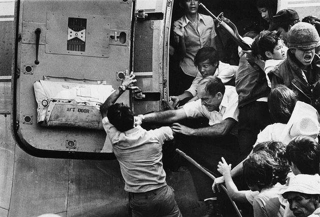 A man trying to board an overloaded evacuation plane is stopped by an American official at Nha Trang Air Base in South Vietnam – Author: manhhai – CC by 2.0