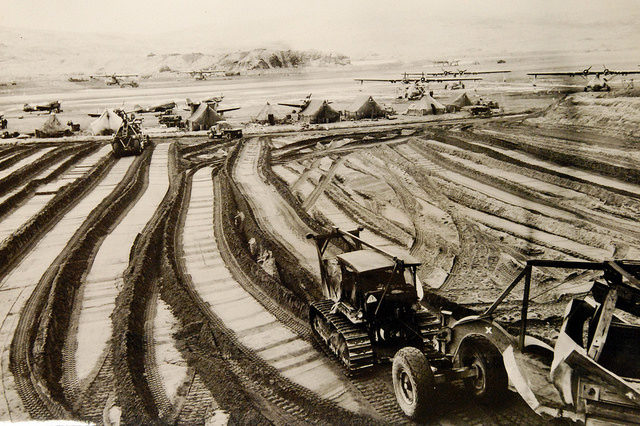 Tractors and grading machines grind out pathways in the stubborn soil of Adak, during the construction of bases on Aleutian strongpoints – Author: National Museum of the U.S. Navy – CC by 2.0