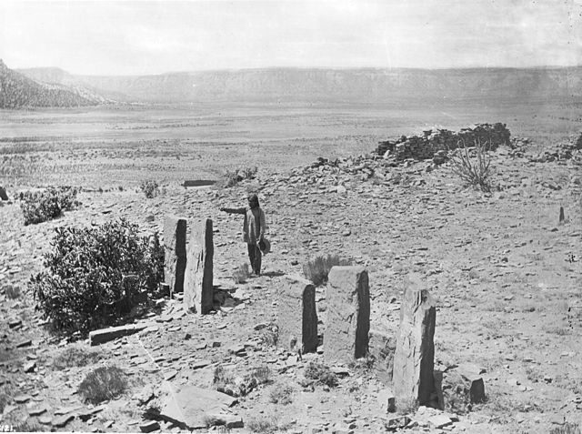 Zuni Indian man worshiping in front of the Old Zuni stone idols, 1900