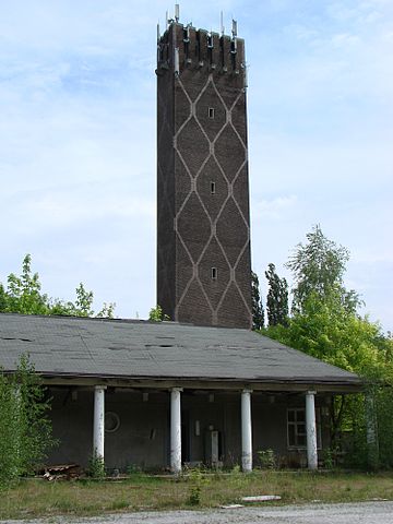 Former Cavalry School Krampnitz. Tower at the entrance (east side) to the military and driving school, 2007 – Author: Elvira Schmidt – CC BY-SA 3.0
