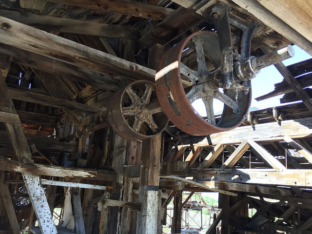 Overhead pulleys and drive shaft in Chemung Mine mill – Author: The Greater Southwestern Exploration Company – CC BY 2.0