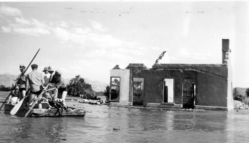 A salvage crew rafts through the town of St. Thomas near the ruins of a building as Lake Mead begins to submerge it in June 1938 – Author: Lake Mead NRA Public Affairs – St. Thomas Evacuation – CC BY-SA 2.0