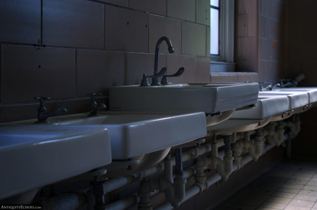 A row of sinks along the brick wall