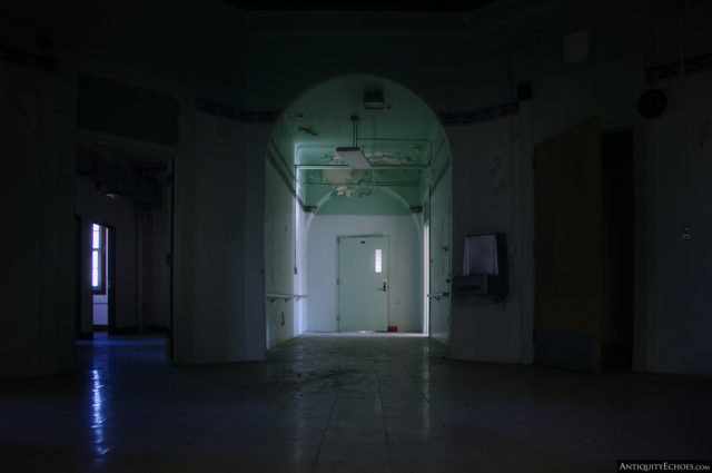 A dark room with a partially lit entrance