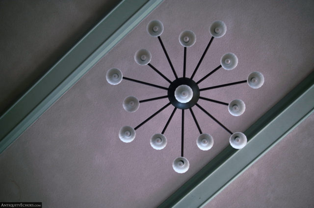 A chandelier on the hospital's pink and mint green ceiling