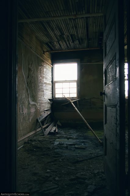 Dilapidated room lit only by a single window
