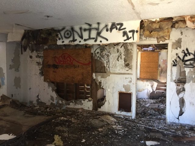 Rotting interior of a building with graffiti on the walls