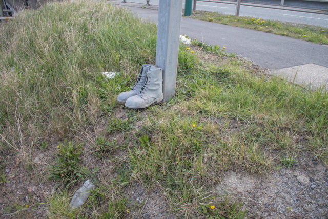 Boots lined up against a wooden post