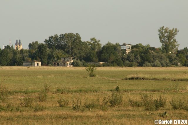 Buildings covered by trees in the horizon at Kalocsa Airfield