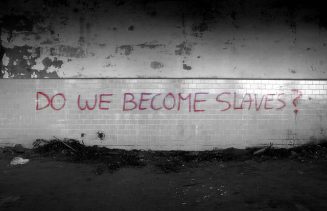 "DO WE BECOME SLAVES?" graffiti on a wall