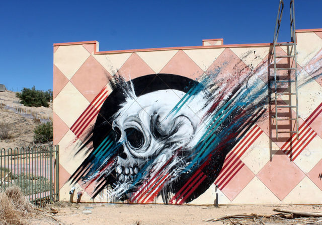 Skull painted along the side of a pink and white checkered building