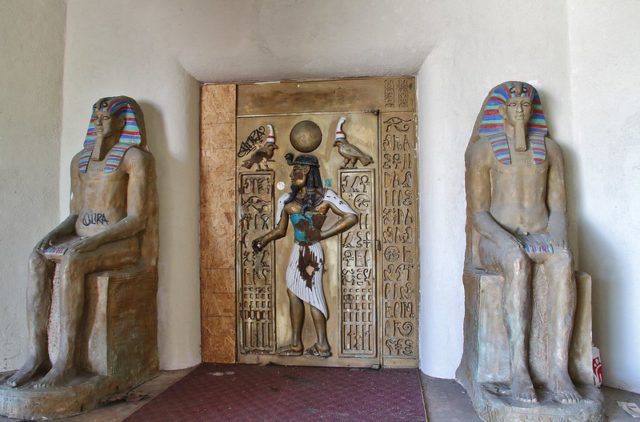 Two ancient Egyptian statues standing beside the entrance to Magic Island