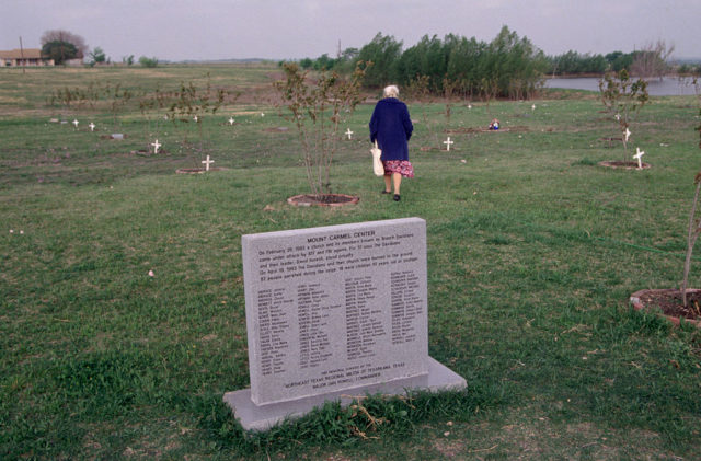 Man walking behind a memorial dedicated to the Branch Davidians