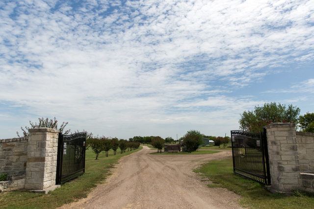 Gates open around a dirt road