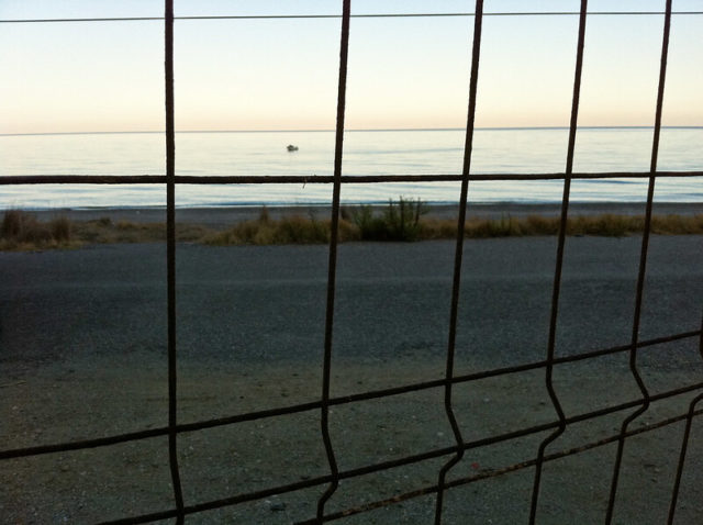 View of the ocean through a chainlink fence