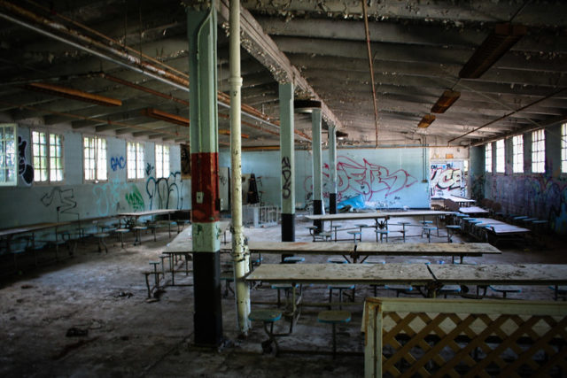 Cafeteria tables in a graffiti-covered room