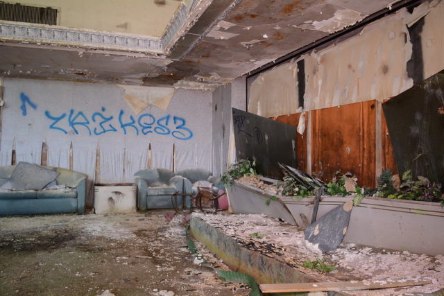 Couches along the wall of a debris-filled room