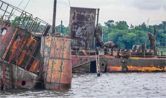 Rusty boat in the water at the Staten Island Tugboat Graveyard