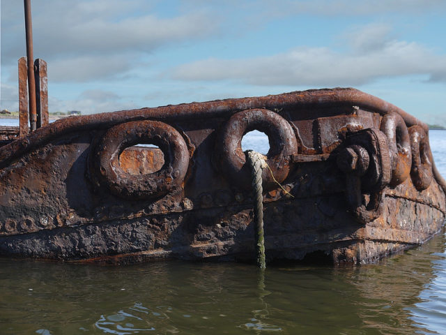 Rusty tugboat popping out of the water