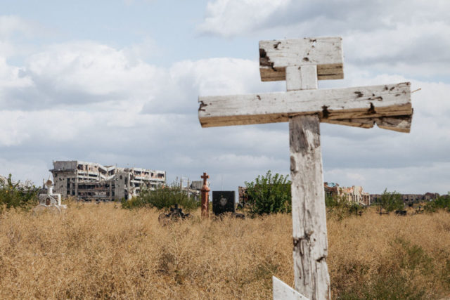 Wooden cross, with Donetsk International Airport in the background