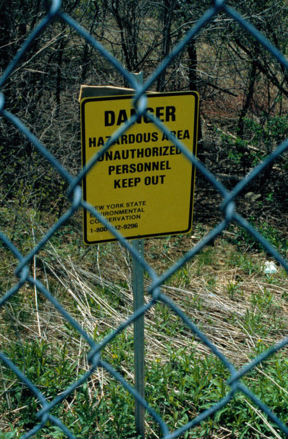 Hazard sign behind a gated fence