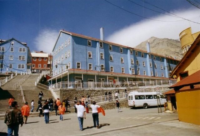 Tourists in front of the blue building. Author: Peraltita CC BY-SA 1.0