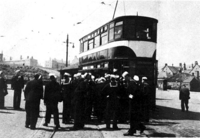 U.S. Navy sailors from the aircraft carrier USS Randolph (CV-15) in front of a double-decker tram in Edinburgh