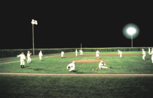 Baseball players on a baseball diamond at night.
