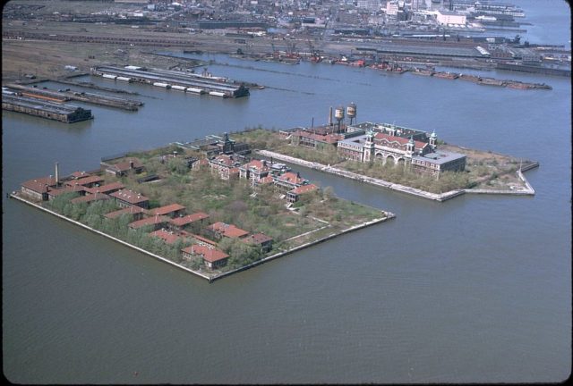 Ellis Island as seen from the air in the early 1970s, with the hospital at the southern (left) side of the island which was created with landfill.