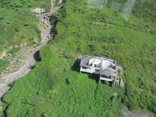 Abandoned home damaged by flying boulders. Author: Leonora (Ellie) Enking CC BY-SA 2.0