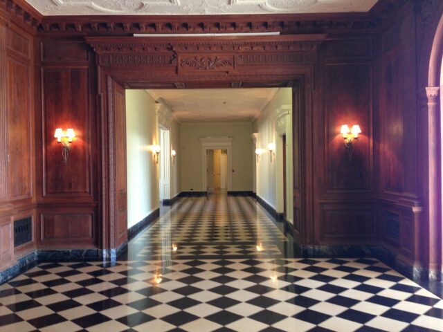 A hallway with checkerboard tile flooring.