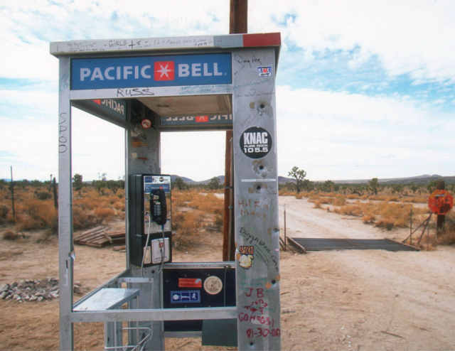 A phone booth in the desert.