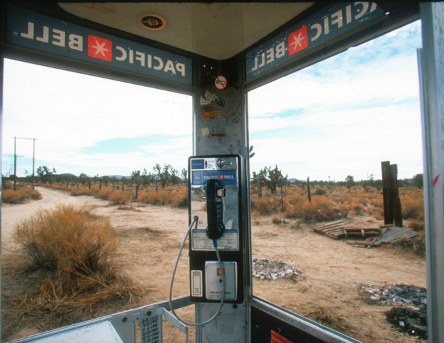 The inside of a phone booth located in the desert.