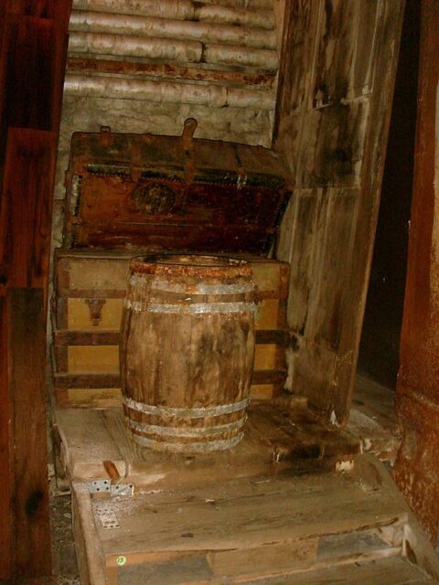Wooden barrel placed in front of a large trunk