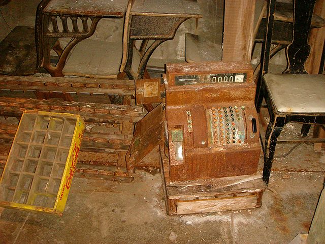 Cash register and chairs covered in dust