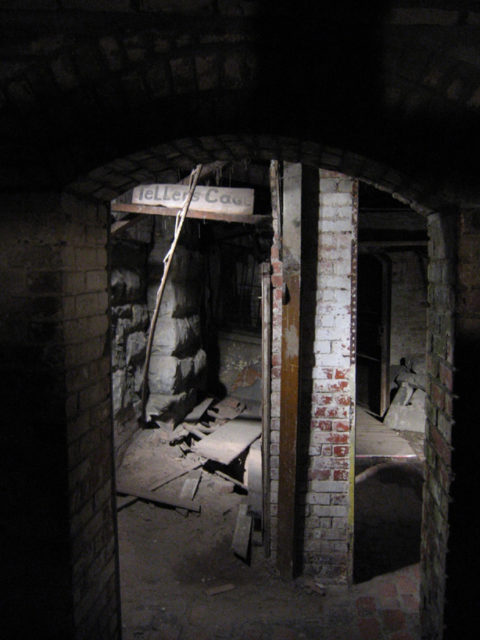 A former bank seen on Bill Speidel’s Underground Tour; the vault door is in the background on the right. Author: Postdlf CC BY-SA 3.0