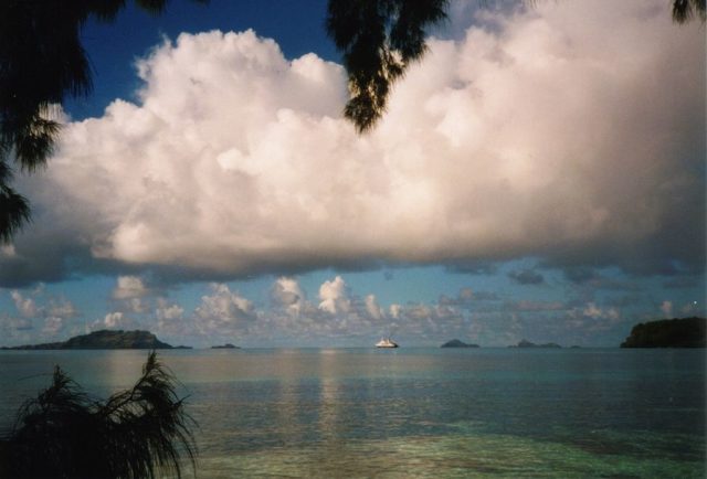 View across the lagoon of the Gambier Islands, French Polynesia, with World Discoverer in the center. Photo Credit: Makemake, CC BY-SA 3.0