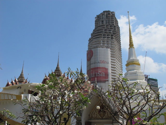 Sathorn Unique Tower in the back, roof of a temple up front. Photo Credit: john, CC BY-ND 2.0