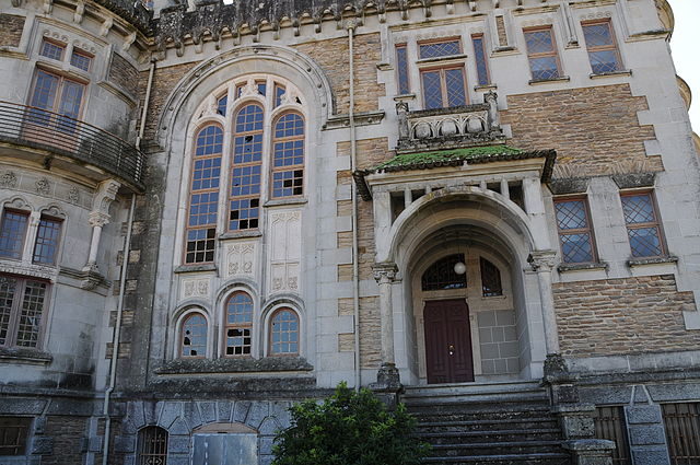 Detail of the front entrance, showing the large arcade windows. Photo credit: José Goncalves, CC BY 3.0