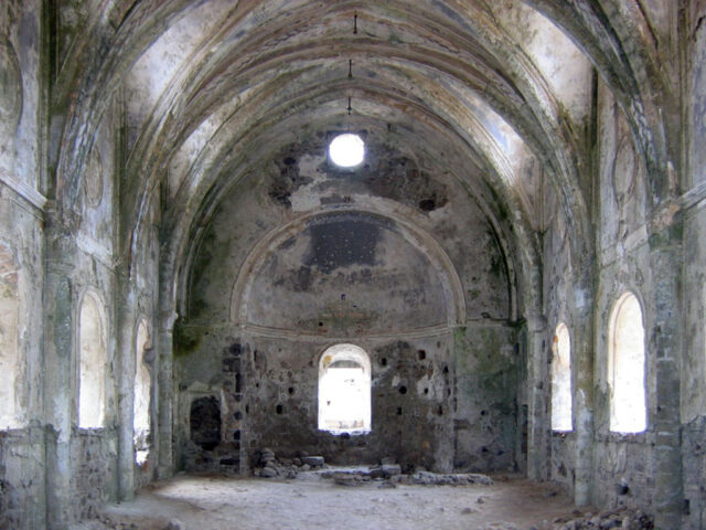 The interior of an abandoned stone church.