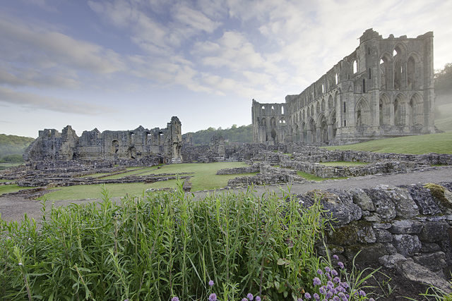 Rievaulx Abbey showing Presbytery (right), South Transept, Chapter House foundations and wall of Infirmary (left). Author: WyrdLight.com – CC BY-SA 3.0