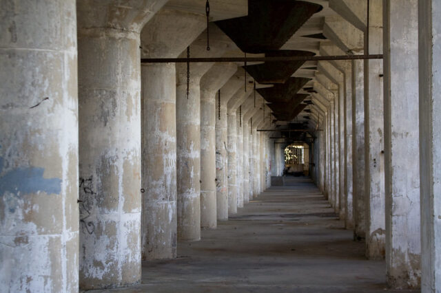 Hallway lined by concrete pillars