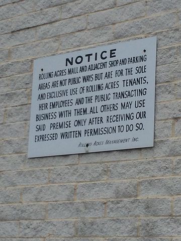 Remaining sign on the side of the former Dillard’s building, warning that the property is only for use by Rolling Acres patrons – Author: UA757 – CC BY-SA 3.0