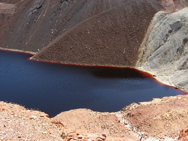 Water in the pit is red due to iron and is acidic from sulfur oxidation – Author: Ceinturion – CC BY 2.5