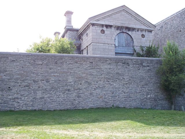 The gallows towering over the stone wall. Author: Jc128842 Public Domain