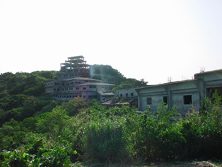 The unfinished complex is slowly overtaken by vegetation